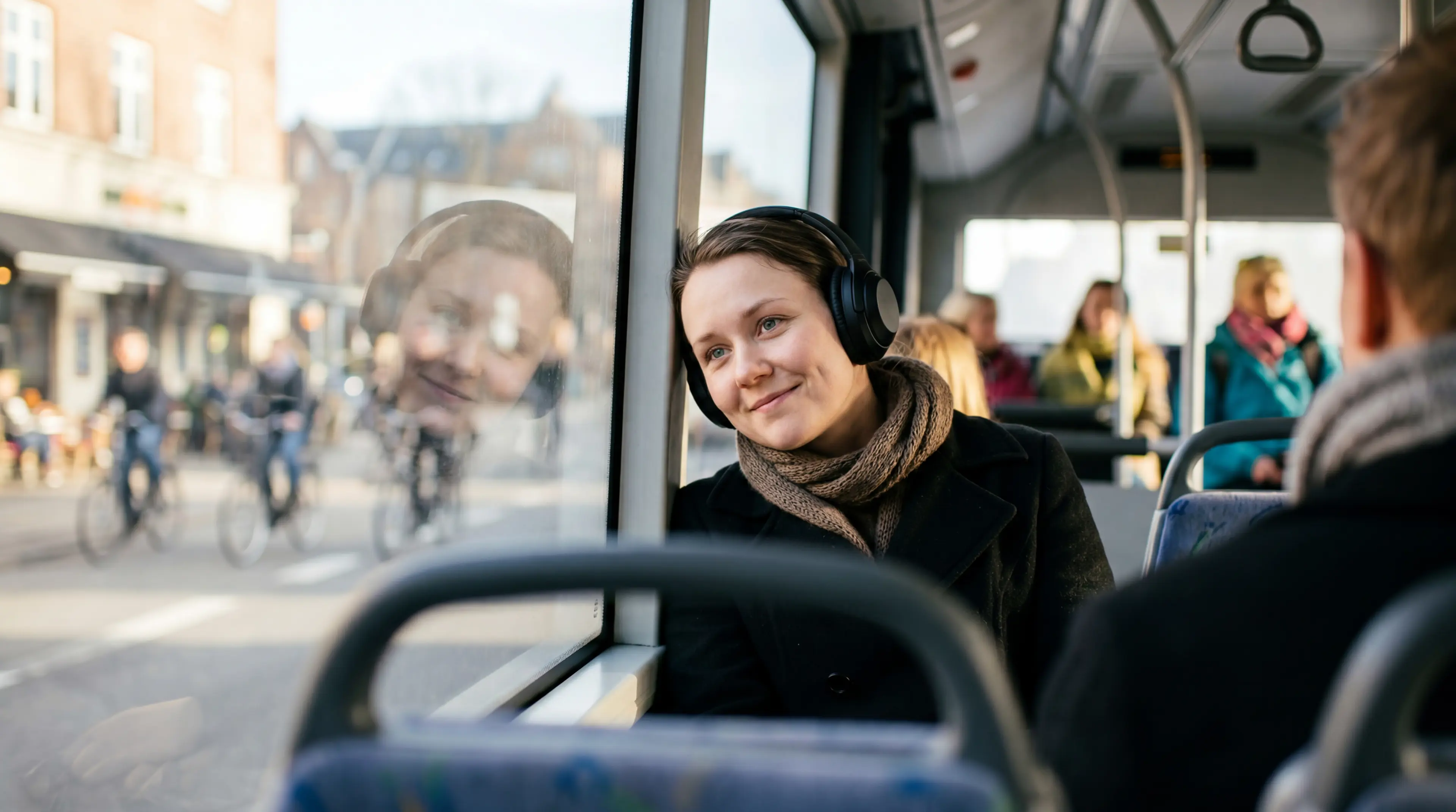 Ung kvinde i bussen på vej videre med økonomisk tryghed og hjælp til jobsøgning